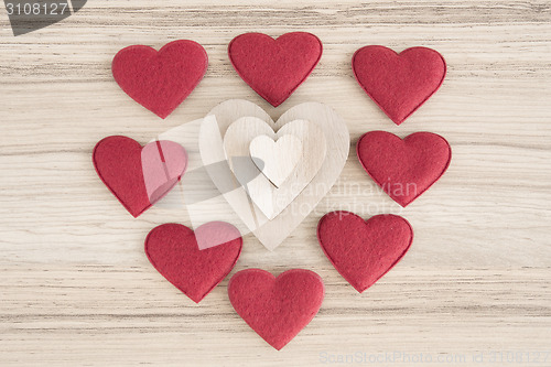 Image of valentine's fabric and wooden hearts on a wooden background