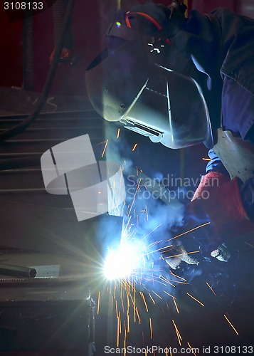 Image of Welder with protective mask welding 