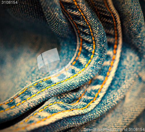 Image of old Jeans with yellow stitching thread