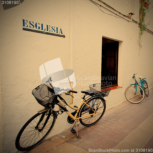 Image of two bicycles at a white wall