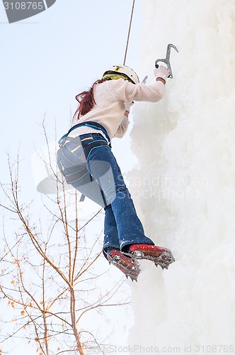 Image of Girl climbs upward on ice climbing competition