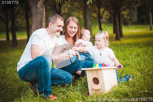 Image of Happy family with nesting box and paints