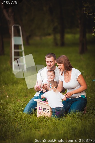 Image of Happy family with nesting box and paints