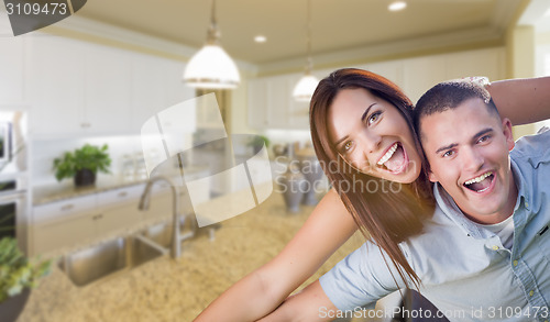 Image of Playful Young Military Couple Inside Beautiful Custom Kitchen