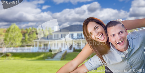 Image of Playful Young Military Couple Outside Beautiful Home