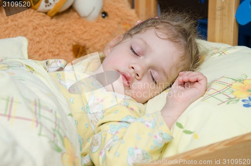 Image of Three year old girl sleeping in her crib