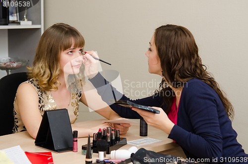 Image of Makeup artist apply makeup to eyelashes office employee