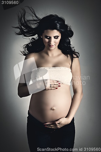 Image of Pregnant woman over dark background