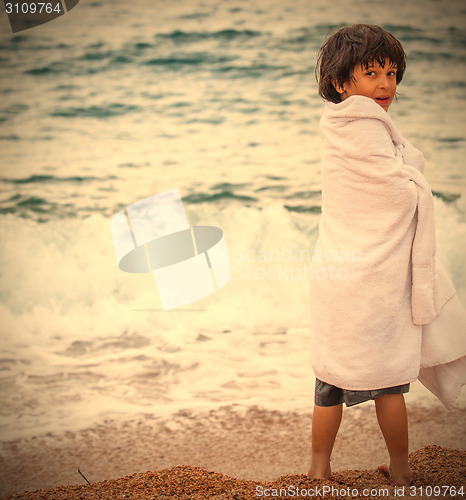 Image of boy wrapped in a towel on the beach
