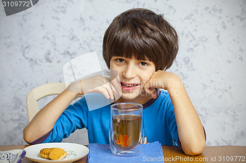 Image of boy with tea and biscuits