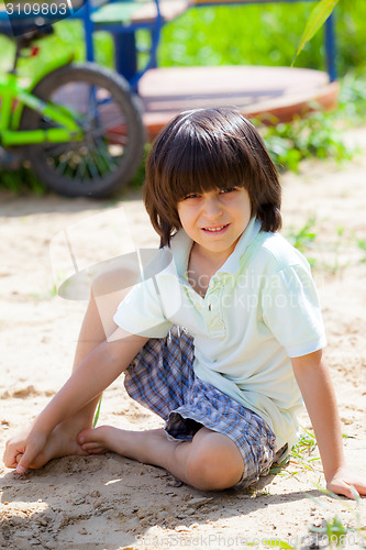 Image of boy sitting on the sand