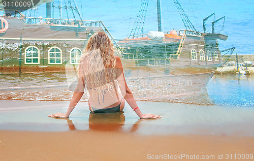 Image of The young girl sits by the sea near water.