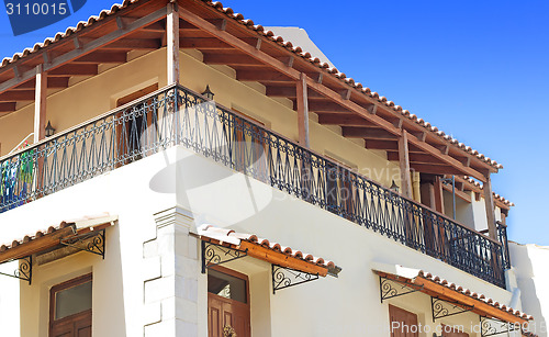 Image of Detail of the facade of an old house with balconies and a sun aw