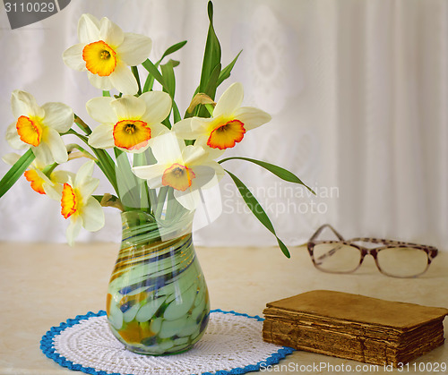 Image of Blossoming narcissuses in a vase on a table.