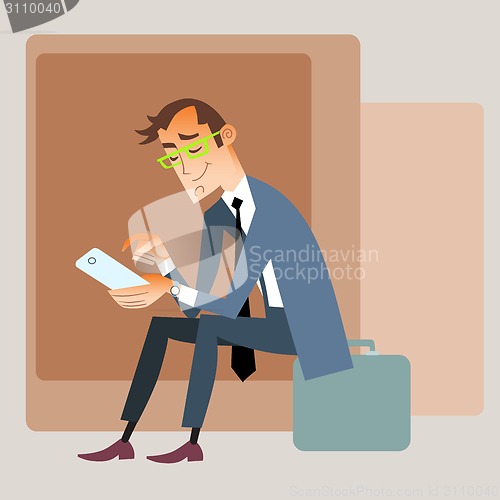 Image of Businessman traveler sits on the bag and reads smartphone