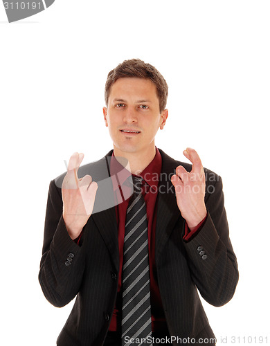 Image of Businessman crossing his fingers.