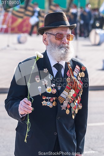 Image of Elderly veteran of World War II walks outdoors