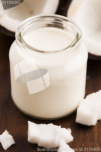 Image of Coconut Milk in a glass on dark wooden background