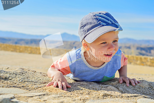 Image of Smiling little boy laying down on the rock