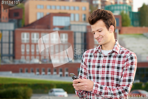 Image of Man with cellphone outdoors