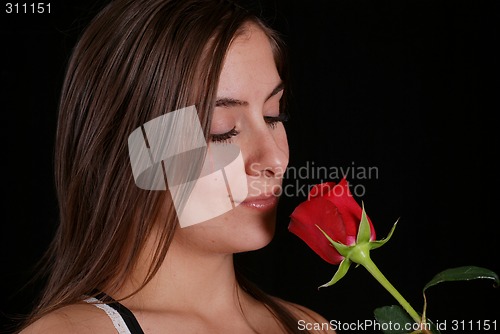 Image of Woman smelling a red rose