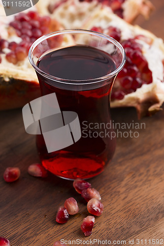 Image of Ripe pomegranates with juice on table