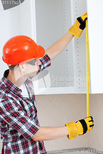 Image of builder with yellow tape measure