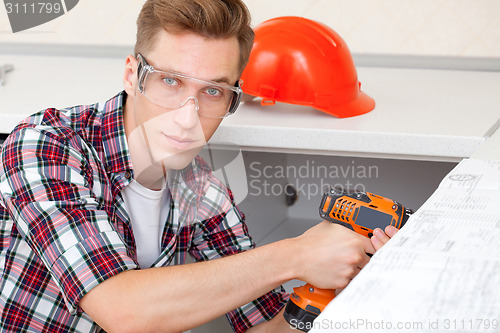 Image of young worker with drill