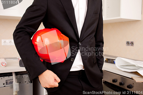 Image of businessman holding red helmet