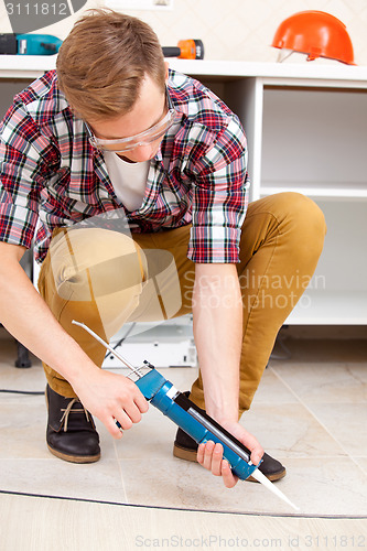 Image of repairman repairing the floor