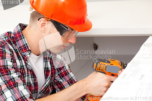 Image of repairman with electric drill 