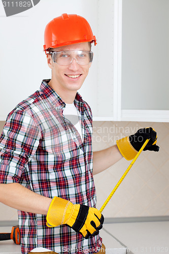 Image of  builder measures the length