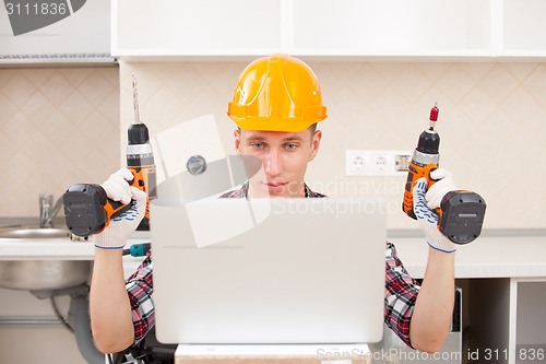 Image of repairman with a drill near a computer