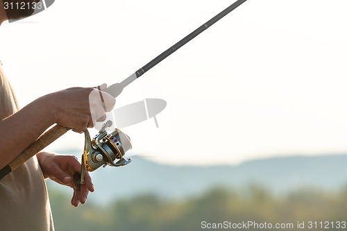 Image of Modern clean fishing rod in hands