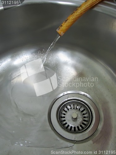 Image of Metal sink and plastic hose