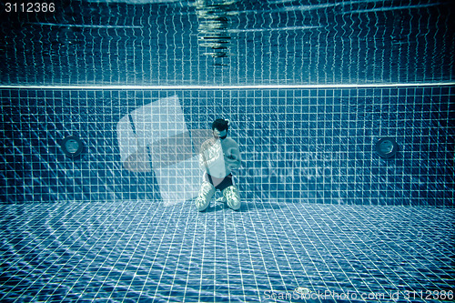 Image of Man praying under water pool