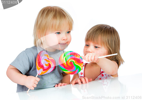 Image of Babies eating a sticky lollipop