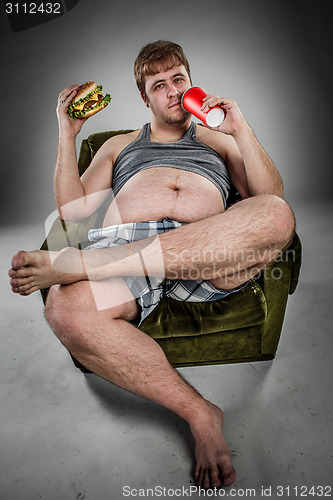 Image of Fat man eating hamburger