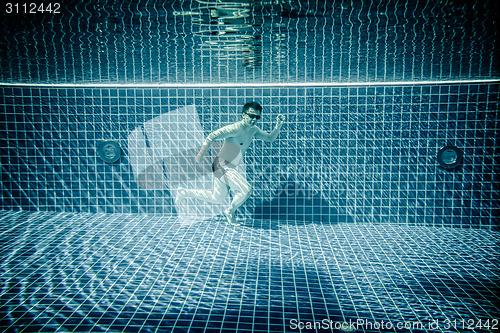 Image of Man runs underwater swimming pool