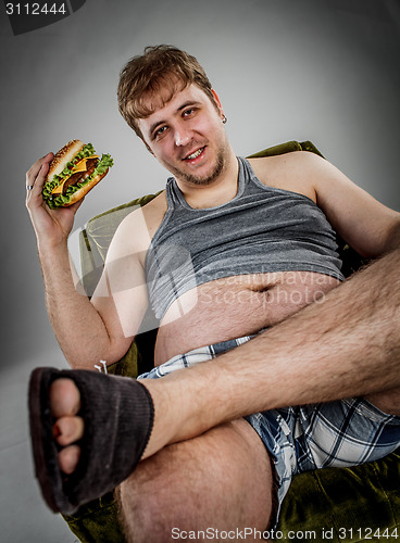 Image of Fat man eating hamburger