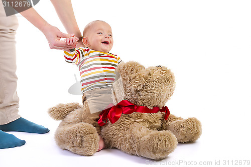 Image of baby boy over plush dog on white 