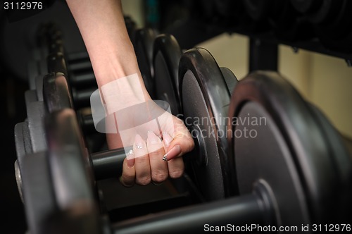 Image of Female hand holding dumbbell