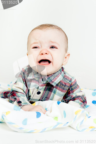Image of Adorable baby screaming in a plaid shirt