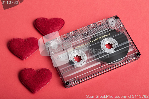 Image of Audio cassette tape on red backgound with fabric heart