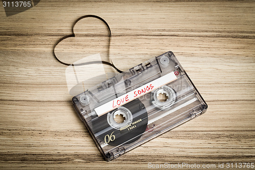 Image of Audio cassette tape on wooden backgound. Film shaping heart