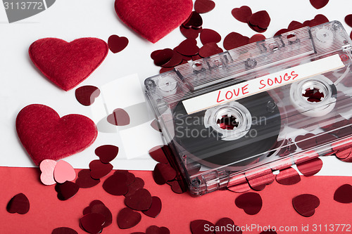 Image of Audio cassette tape on red backgound with fabric heart