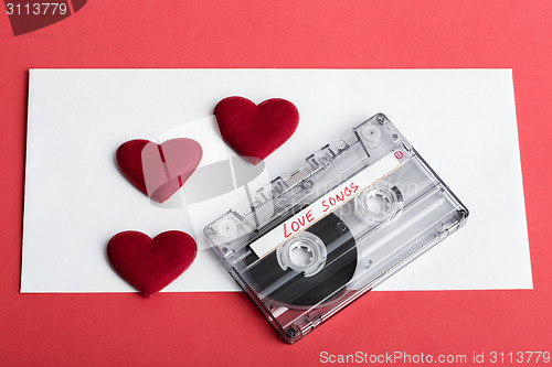 Image of Audio cassette tape on red backgound with fabric heart