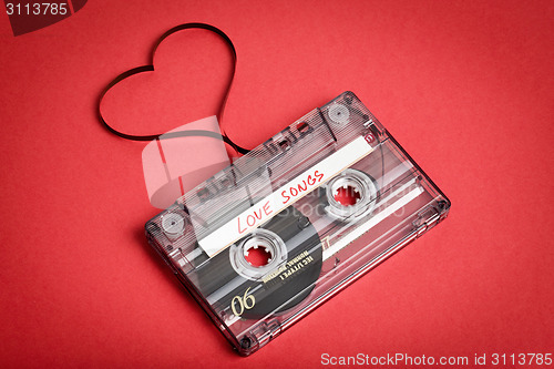 Image of Audio cassette tape on red backgound. Film shaping heart