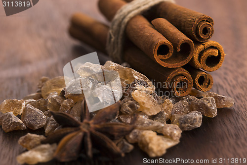 Image of Cinnamon sticks with pure cane brown sugar on wood background