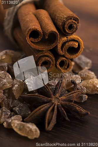 Image of Cinnamon sticks with pure cane brown sugar on wood background